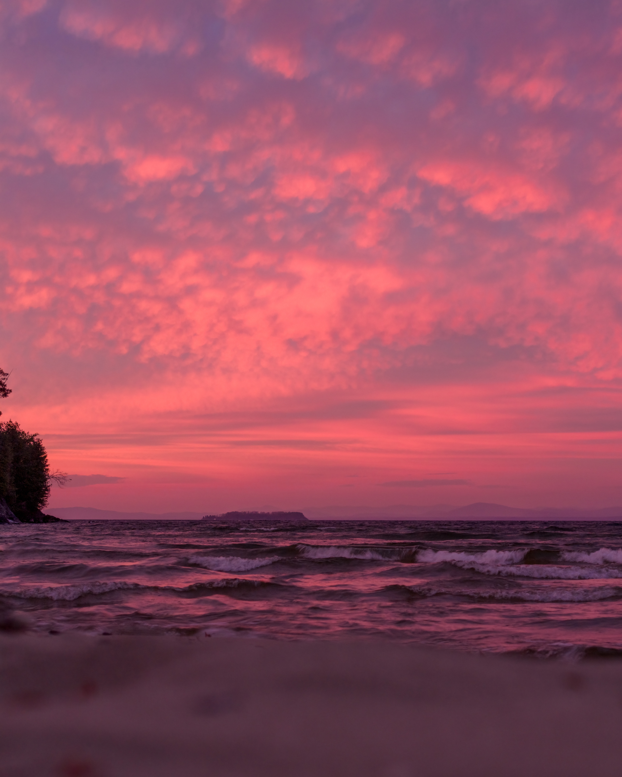 a vertical panorama of a shoreline and sunrise.